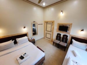 a hotel room with two beds and a television at Hotel Temple On Ganges in Varanasi