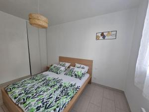 een slaapkamer met een bed met een groene deken en kussens bij Maison de campagne en Provence in Noves