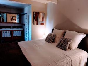 a bedroom with a large white bed with two pillows at Le Moulin du Porteil in Campagne