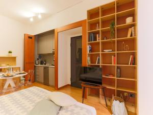 a living room and kitchen with a large book shelf at The Best Rent - Modern apartment in the center in Milan +14 photos