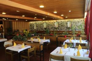 a dining room with white tables and chairs and flowers at Hotel-Restaurant Stechelberg Bed & Breakfast in Stechelberg