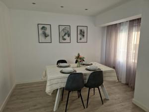 einen Esstisch mit 4 Stühlen in einem weißen Raum in der Unterkunft My home in Gijón Apartamento - VUT4494AS in Gijón