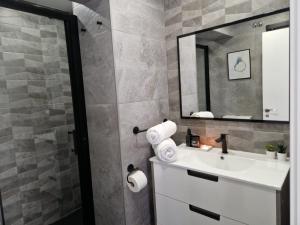 ein Bad mit einem Waschbecken und einem Spiegel in der Unterkunft My home in Gijón Apartamento - VUT4494AS in Gijón