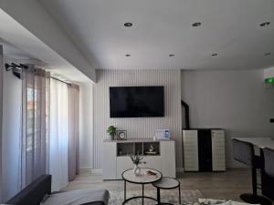 ein Wohnzimmer mit einem TV und einem Tisch in der Unterkunft My home in Gijón Apartamento - VUT4494AS in Gijón