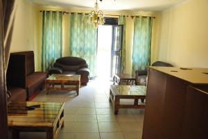 a living room with a couch and chairs and a table at Namulanda Motel in Entebbe