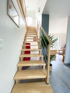 - un escalier dans une maison dotée d'un tapis rouge et blanc dans l'établissement Maison de charme, Les Voiles à Sainte Marine, à Combrit