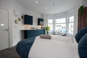 a bedroom with a large white bed with blue cabinets at Morecambe Bay Studio Flats Free Parking Beach Front in Morecambe +10 photos