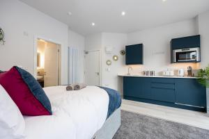 a bedroom with a large bed and a kitchen at Morecambe Bay Studio Flats Free Parking Beach Front in Morecambe