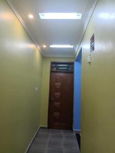 a hallway with a brown door and a ceiling at Tilvia home stay in Kitui. The holiday home in Tulia