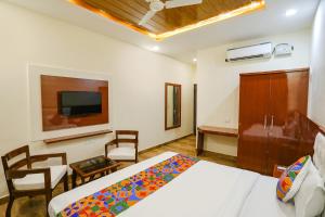Habitación de hotel con cama y TV en FabExpress Trijal Inn, en Lucknow