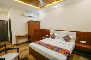 1 dormitorio con 1 cama grande y escritorio en FabExpress Trijal Inn, en Lucknow