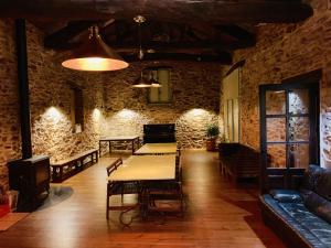 Les Coumayres في Riols: غرفة طعام مع طاولة وكراسي وجدار حجري
