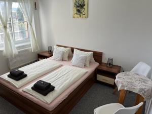 een slaapkamer met 2 bedden en zwarte handdoeken bij Parkhotel Smržovka in Smržovka
