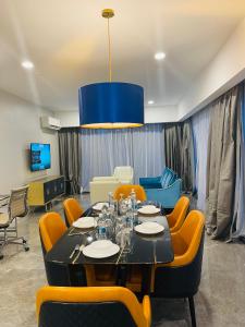 uma sala de jantar com uma mesa e cadeiras amarelas em KLCC Platinum 2 by Hibernate em Kuala Lumpur