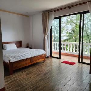 フーコックにあるKim Lien Phu Quoc Guesthouseのベッドと大きな窓のある寝室