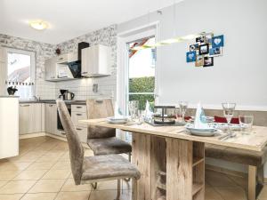 a kitchen with a wooden table and chairs at FH Harmonie in Kaltenhof