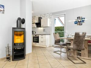 a kitchen with a fireplace and a table with chairs at FH Harmonie in Kaltenhof