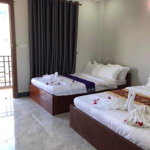 a hotel room with two beds with towels on them at Kro Nhep Guesthouse in Kampot