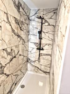 a bathroom with a shower with marble walls at Kaoglen Buck Pod - Hot Tub - Feature - Pets in Blairgowrie