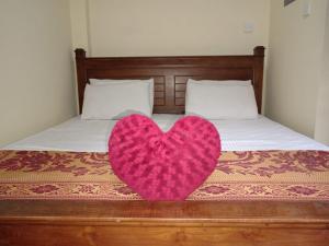 a pink heart sitting on top of a bed at Tea Leaf Guest House Castlereagh in Hatton