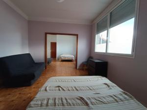 a bedroom with a bed and a couch and a window at Appartement spacieux in Montreuil