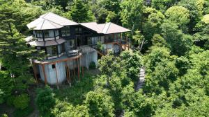 eine Luftansicht eines Hauses im Wald in der Unterkunft プライベートリゾート碧海 in Okawa