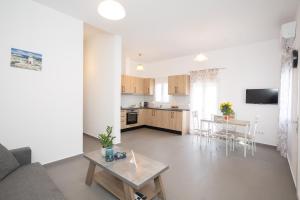 Spilia Apartments & Suites Mykonos في Agrari: غرفة معيشة ومطبخ مع أريكة وطاولة
