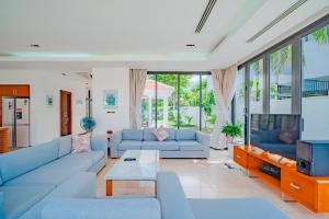 sala de estar con sofás azules y TV en The Ocean Resort, en Da Nang