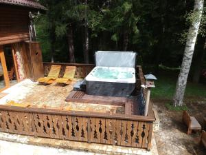 a hot tub on a deck with two chairs at Villa Borovets Mountain & Luxury in Borovets