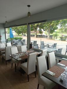 un restaurante con mesas y sillas y una gran ventana en Auberge du pont canal, en Briare