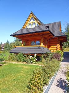 una cabaña de madera con techo de gambrel en Przystań w Tatrach - Przytulne Domki i Apartamenty-Luxury Chalets and Apartments, en Bukowina Tatrzańska