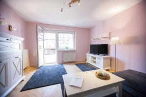 een woonkamer met een tafel en een tv bij Ferienhaus OG1 "Westerwald Blick" in Martinfeld +18 foto's