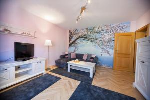 een woonkamer met een bank en een tv bij Ferienhaus OG1 "Westerwald Blick" in Martinfeld