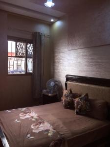 a bedroom with a large bed with a window at Airport M V chambre stay in Deroua