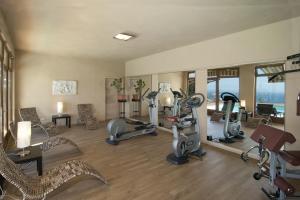 a gym with treadmills and exercise equipment in a room at Hotel Mariano in Gargnano