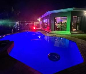 a swimming pool with blue lighting in front of a house at 2 on Haig Accommodation, Selbourne, East London in East London