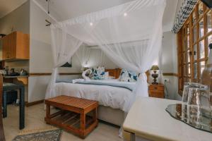 a bedroom with a bed with a canopy at Beetleloop Guest House in Nelspruit