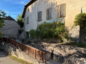 ein altes Haus mit einem Zaun davor in der Unterkunft Gite Au pied du Grand Colombier in Talissieu