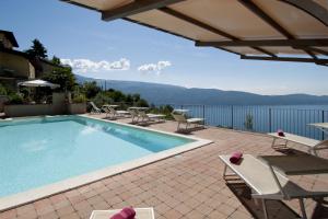 a swimming pool with chairs and a view of the water at Hotel Mariano in Gargnano