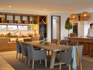 una cucina e una sala da pranzo con tavolo e sedie in legno di Walkers Beach a Plettenberg Bay