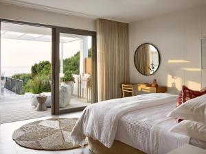 a bedroom with a large bed and a sliding glass door at Walkers Beach in Plettenberg Bay