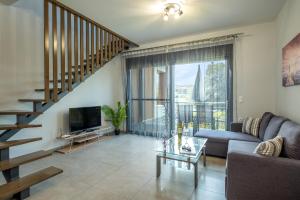 a living room with a couch and a tv and a staircase at Villa Artemis A&B in Chania Town