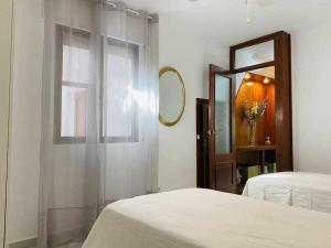 a bedroom with a bed and a mirror and a window at Acogedora casa con terraza y chimenea in Marbella