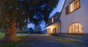 a white house with a tree in front of it at Blu Lavanda Bed & Breakfast in Luserna San Giovanni