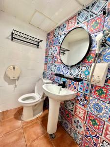 ein Bad mit einem WC und einem Spiegel in der Unterkunft Taipei Triple Tiger Inn in Taipeh