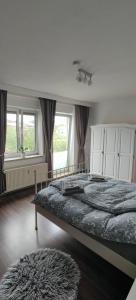 a bedroom with a large bed and two windows at Zimmer Nähe Darmstadt in Roßdorf