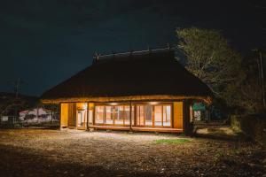 a small house with a thatched roof at night at chigiterasu shintomi miyazaki - Vacation STAY 44990v in Saito