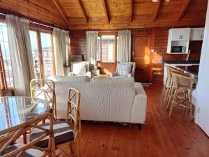 a living room with a couch and a table and chairs at The beach cabin with pool in Port Alfred