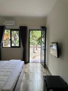 1 dormitorio con 1 cama y puerta corredera de cristal en Color Inn - Homestay & Cafe en Ninh Hải
