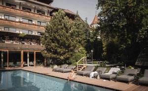 a woman is standing in the swimming pool at a hotel at Hotel Lanerhof active/spa/balance in San Lorenzo di Sebato